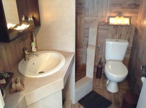 La salle de bains est pourvue d'un lavabo blanc et de toilettes. dans l'établissement Traditional house with great view 90m from the sea, à Salamine
