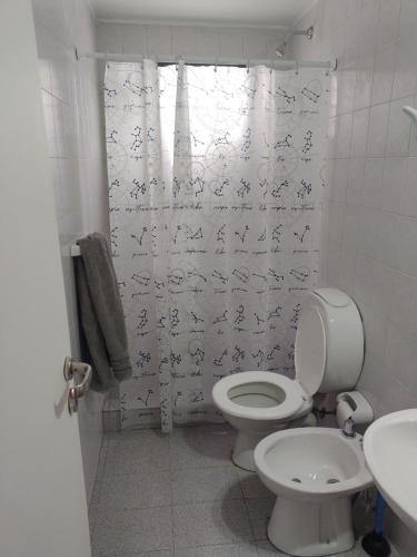 a bathroom with a toilet and a shower curtain at Departamento Céntrico Trelew in Trelew