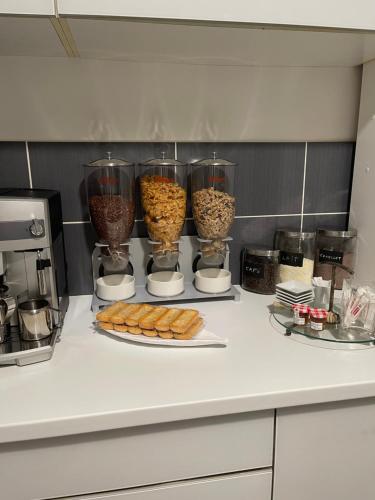 a kitchen counter with some food in glass containers at La Maison de l Echauguette Petit Dejeuner et Menage Offerts in Clermont-Ferrand