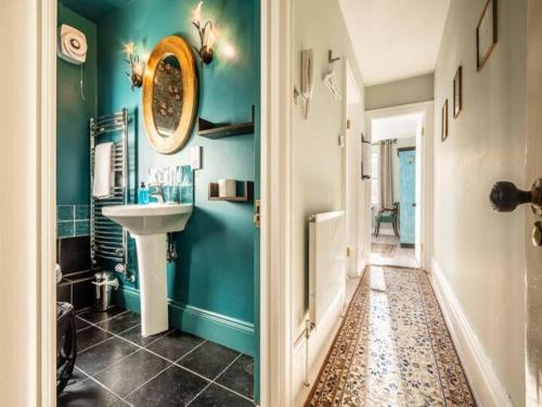 a bathroom with blue walls and a sink at Pass the Keys Garden View Period Dartmoor apartment with garden views in Chagford