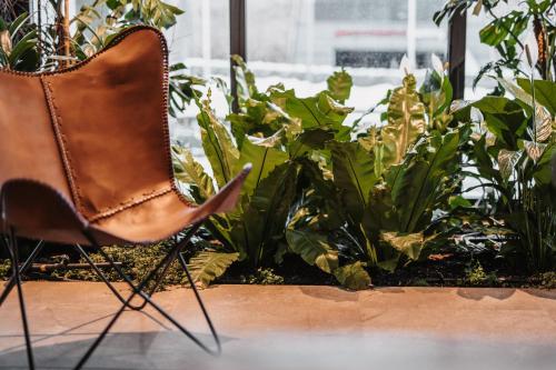 a brown chair sitting in front of plants at kerii - adults boutique hotel in Saalbach Hinterglemm