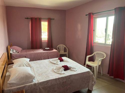 a bedroom with two beds and a window with red curtains at Casa Ze & sonia in Portela