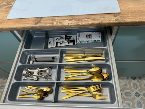 a drawer filled with gold utensils and silverware at Castaños 4 in Alicante