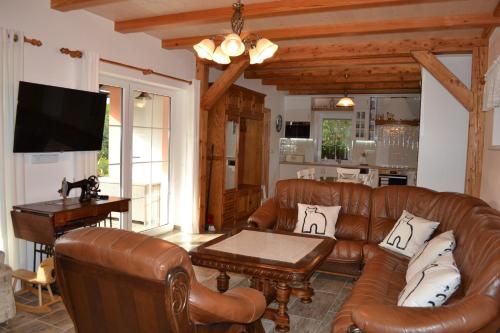 a living room with a leather couch and a table at Ubytování Slezská Harta in Nová Pláň