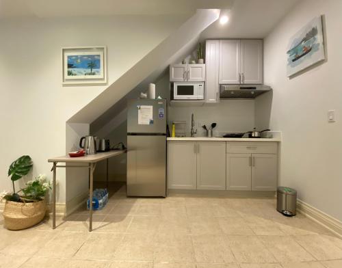 a kitchen with a refrigerator and a table at One Deluxe Bedroom Suite in Midtown in Toronto