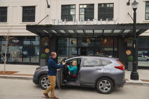 a man and a woman getting out of a car at The Bradley in Fort Wayne