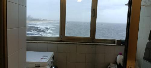 a window in a bathroom with a view of the ocean at Matosinhos -Seas Apartment- Cabo das Marés in Matosinhos