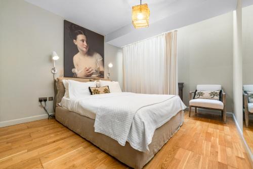 um quarto com uma cama e um retrato de um homem em Sophia Gardens Apartment em Cardiff