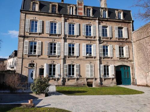 ein großes Backsteingebäude mit grüner Tür in der Unterkunft Superbe T2 neuf dans maison de maitre hyper centre in Épinal