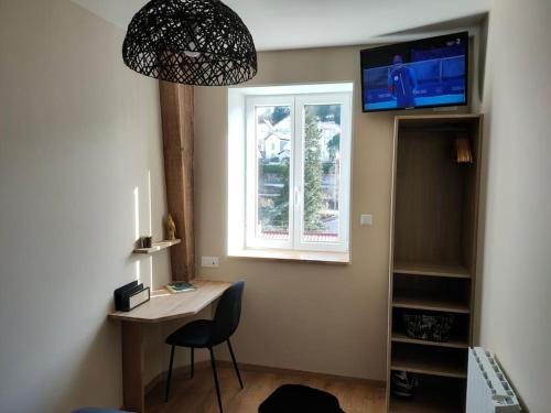 Cette chambre comprend un bureau avec une chaise et une fenêtre. dans l'établissement Superbe T2 neuf dans maison de maitre hyper centre, à Épinal