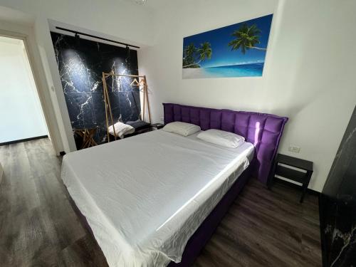 ein Schlafzimmer mit einem lila Bett in einem Zimmer in der Unterkunft סוויטה בזכרון in Zichron Ja’akow