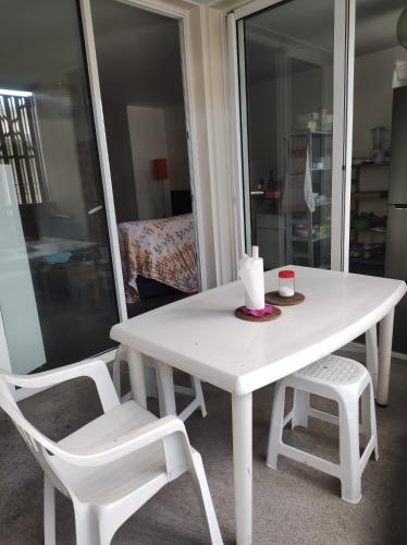 Appartement 2 chambres étang sale في إيتانغ-ساليه: طاولة بيضاء وكرسيين بيض في الغرفة