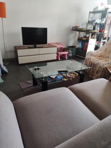 Appartement 2 chambres étang sale في إيتانغ-ساليه: غرفة معيشة مع تلفزيون وطاولة قهوة زجاجية