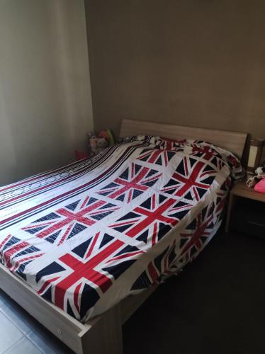 - un lit doté d'une couette à drapeau friable dans l'établissement Appartement 2 chambres étang sale, à L'Étang-Salé