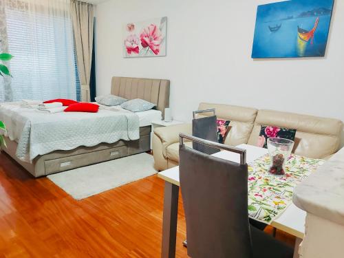 a living room with a bed and a couch at Nova Galerija West App MARY - parking in garage in Zagreb