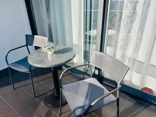 a table and chairs in a room with a window at Nova Galerija West App MARY - parking in garage in Zagreb
