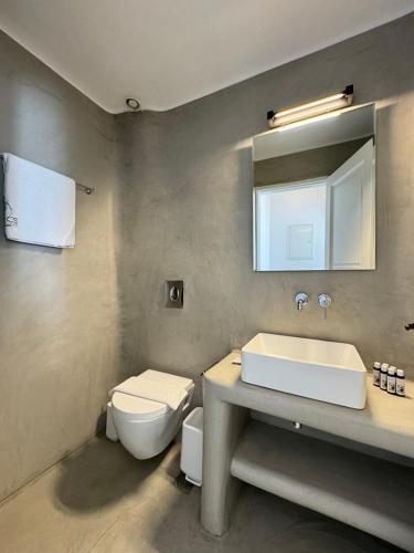 a bathroom with a toilet and a sink and a mirror at Cielo Azul Mykonos in Mikonos