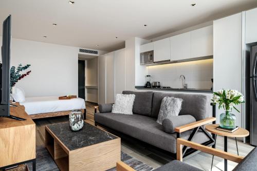 a living room with a couch and a kitchen at Nido x Nomad Las Américas GDL in Guadalajara