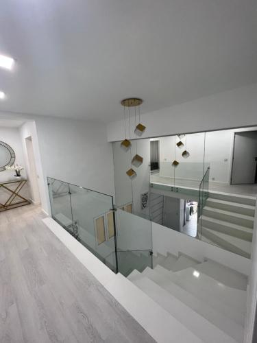 a white room with stairs and a glass railing at Apartamento Belo Horizonte in Funchal