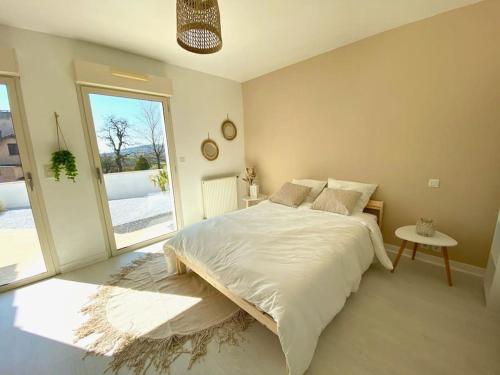 ein Schlafzimmer mit einem großen Bett und einem großen Fenster in der Unterkunft Villa avec piscine d'intérieur “ Losalia “ in Talant