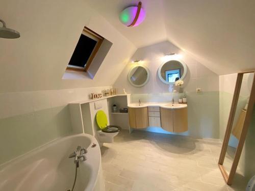 ein Badezimmer mit einer Badewanne, einem WC und einem Waschbecken in der Unterkunft Villa avec piscine d'intérieur “ Losalia “ in Talant
