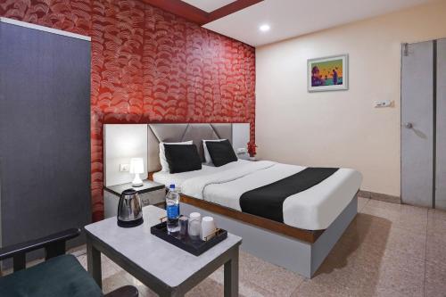 a bedroom with a bed and a table with a couch at Flagship Hotel Crystal in Ahmedabad