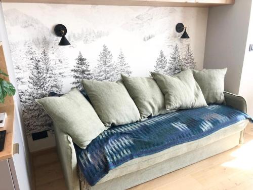 - un canapé avec des oreillers dans une chambre dotée d'un mur recouvert de neige dans l'établissement Appart Centre Chamonix Grande Terrasse Mont Blanc, à Chamonix-Mont-Blanc