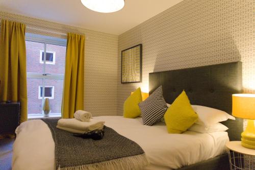 a bedroom with a large bed with yellow pillows at Blue River, Parking subject to availability in York
