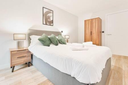 sypialnia z dużym białym łóżkiem z zielonymi poduszkami w obiekcie Lovely Central Birmingham 1 Bed Apartment w Birmingham
