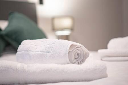 eine Rolle weiße Handtücher auf dem Bett in der Unterkunft Lovely Central Birmingham 1 Bed Apartment in Birmingham