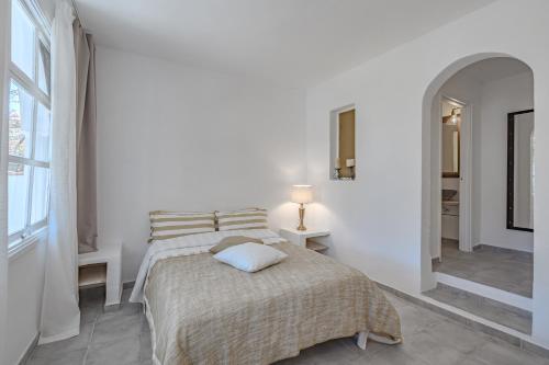a white bedroom with a bed and a window at La Finquita - Adeje in Adeje