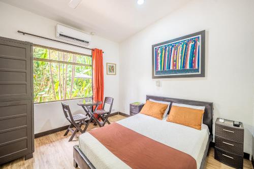 a bedroom with a bed and a window and a table at Jaco Lodge Quiet Place in Jacó