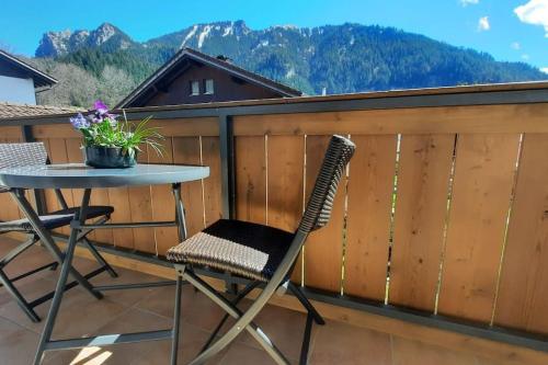 a patio table and chairs on a balcony with mountains at Ferienhaus-Ferienwohnung Weitblick mit Garten und malerischem Bergpanorama in Oberammergau
