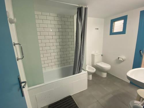 een badkamer met een douche, een toilet en een wastafel bij Hostal Carlos III in El Prat de Llobregat
