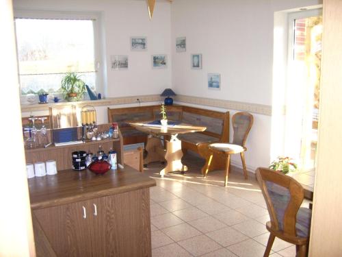 a kitchen with a table and a table and chairs at Pension Regenbogen in Stralsund