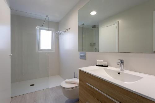 卡拉費若拉的住宿－FERRERA SUITES，一间带水槽、卫生间和镜子的浴室
