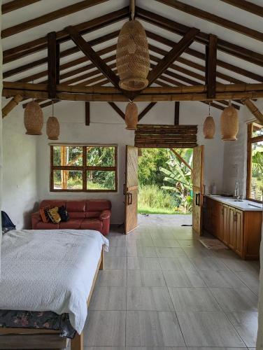 a bedroom with a large bed and a kitchen at Patio Bonito in Jardin