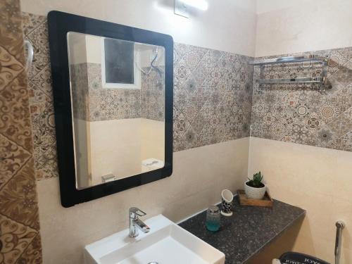 a bathroom with a sink and a mirror at Risals Home Stays in Greater Noida