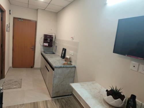 a room with a counter and a tv in a room at Risals Home Stays in Greater Noida