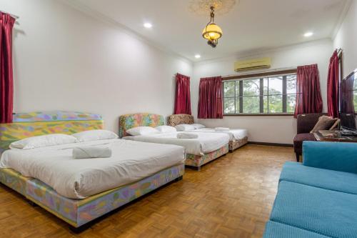 a bedroom with three beds and a couch at Bangsar Villa for groups, event space and family fun in Kuala Lumpur