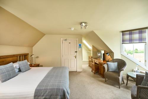 um quarto com uma cama, uma secretária e uma janela em Ulbster Arms Hotel near Thurso em Halkirk