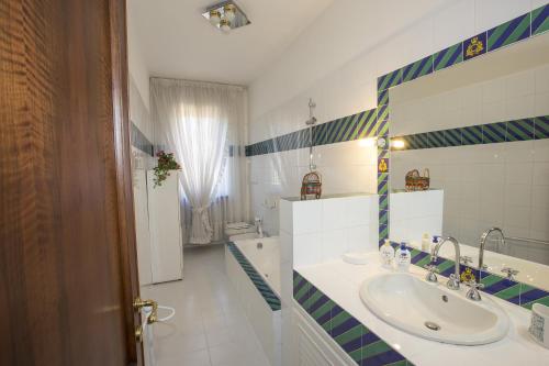 a white bathroom with a sink and a window at La Casa di Gigliola in Monticiano