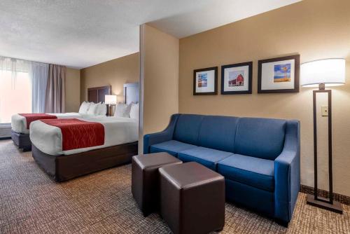 a hotel room with a bed and a blue couch at Comfort Inn & Suites in Goodland