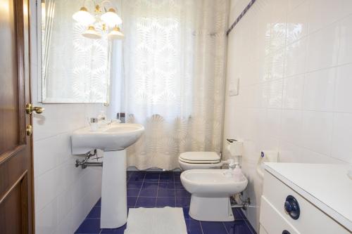 a white bathroom with a sink and a toilet at La Casa di Gigliola in Monticiano