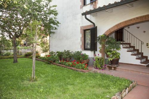 a house with a yard with flowers and plants at La Casa di Gigliola in Monticiano