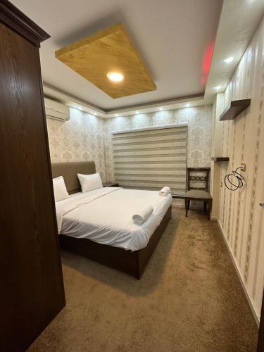 a bedroom with a bed and a chair in it at al-burj apart 7th circle in Amman