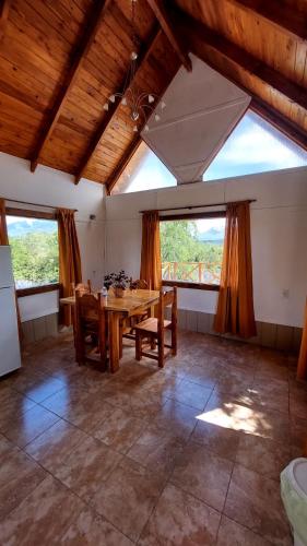 a dining room with a table and some windows at Tito Fly in Cholila