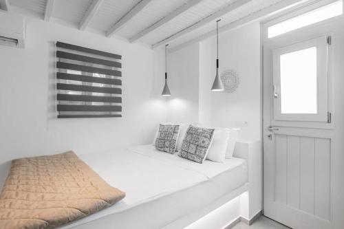 een witte kamer met een bank en een raam bij August Mykonos in Mykonos-stad
