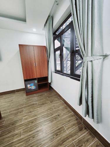 a living room with a window and a wooden floor at Happy Bun Hotel Da Lat in Da Lat