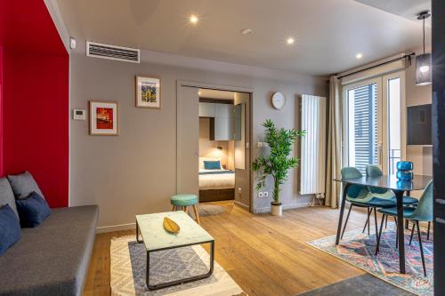 uma sala de estar com um sofá e uma mesa em Les Appartements Cardinet em Paris